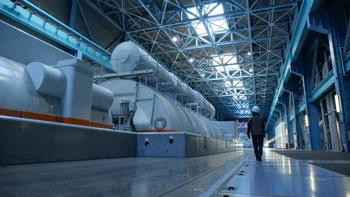 A specialist walking through a power plant turbine hall