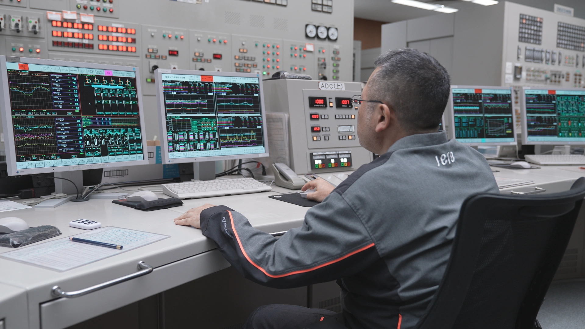An operator analyzing power plant data in a control room