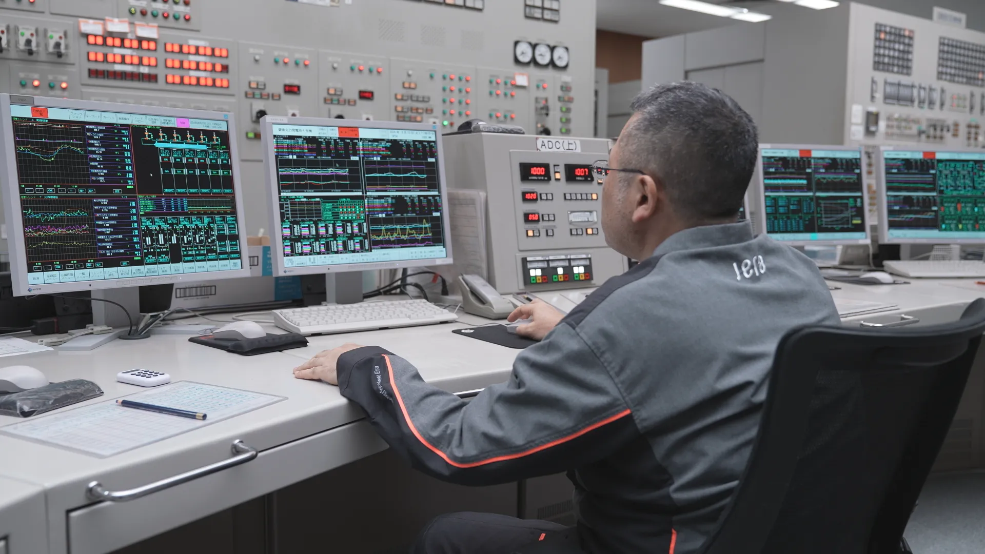An operator analyzing power plant data in a control room