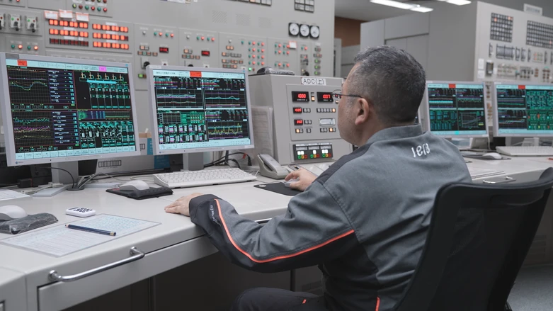An operator analyzing power plant data in a control room